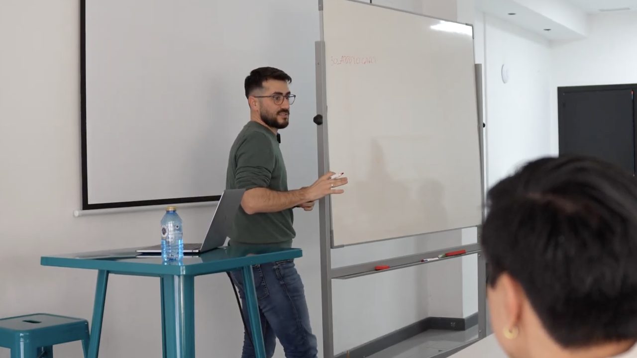 Jorge Alfaro dando clase frente a la pizarra en una escuela de marketing